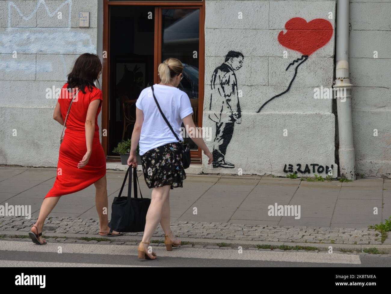 Deux dames marchent à côté d'une nouvelle fresque avec une image du chef du parti droit et Justice au pouvoir, Jaroslaw Kaczynski, par l'artiste de rue 'le Raton' vu dans le quartier Cracovie-Kazimierz. Sur 15 juillet 2020, à Cracovie, petite Pologne Voivodeship, Pologne. (Photo par Artur Widak/NurPhoto) Banque D'Images