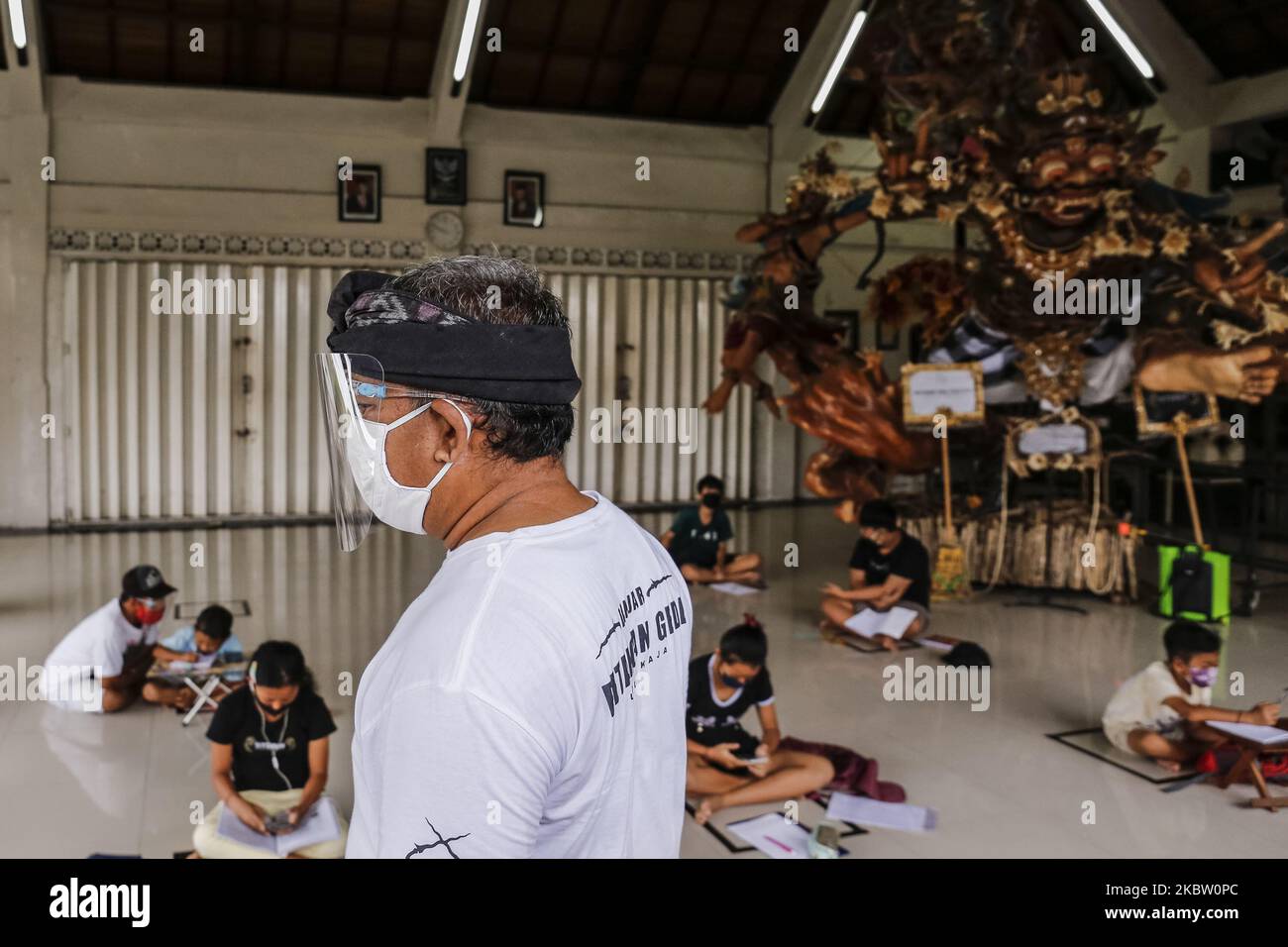 Les autorités locales suivent les élèves qui travaillent sur des devoirs scolaires en ligne en utilisant le réseau Internet gratuit dans la salle publique du village d'Ubung Kaja, Denpasar, Bali, Indonésie sur 21 juillet 2020. Bien que le gouvernement indonésien impose une nouvelle ère normale, les autorités locales ferment encore les écoles dans la zone à haut risque de la propagation de Covid-19 et exhorte les élèves à effectuer des études à domicile en utilisant l'apprentissage en ligne de leurs enseignants. (Photo de Johannes Christo/NurPhoto) Banque D'Images