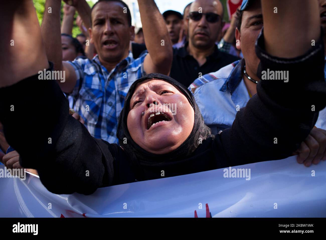 Une Tunisienne pleure son fils qui a été tué à Sidi Bouzid la semaine précédente au mémorial de police des martyrs de la révolution devant le ministère de l'intérieur pour dénoncer la mort de six policiers lors d'un affrontement. Des centaines de manifestants ont pris part à la manifestation devant le ministère dans ce qui a été facturé comme « funérailles nationales symboliques » pour des membres tués des forces de sécurité. Le 28 octobre 2013 à Tunis, Tunisie. (Photo par Emeric Fohlen/NurPhoto) Banque D'Images