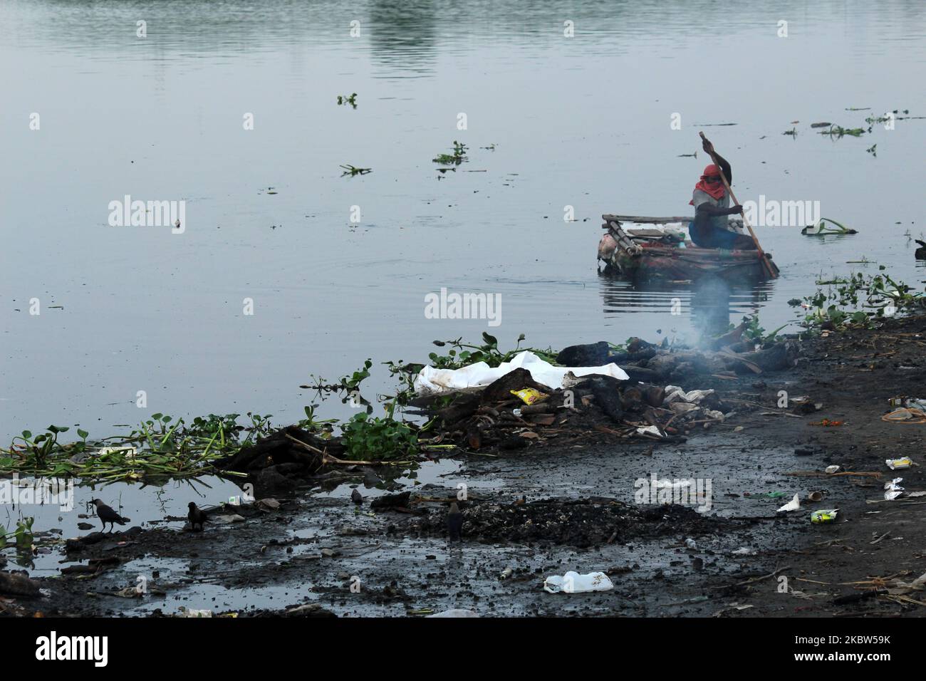 Un collecteur de déchets est vu ramasser du plastique sur un bateau de fortune le long de la rivière Yamuna à New Delhi sur 24 juillet 2020. (Photo de Mayank Makhija/NurPhoto) Banque D'Images