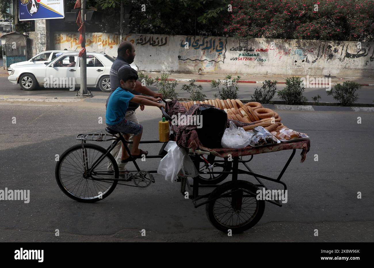 Un vendeur palestinien pousse une voiturette avec du pain lors d'une journée chaude à Gaza, le 27 juillet 2020. (Photo de Majdi Fathi/NurPhoto) Banque D'Images