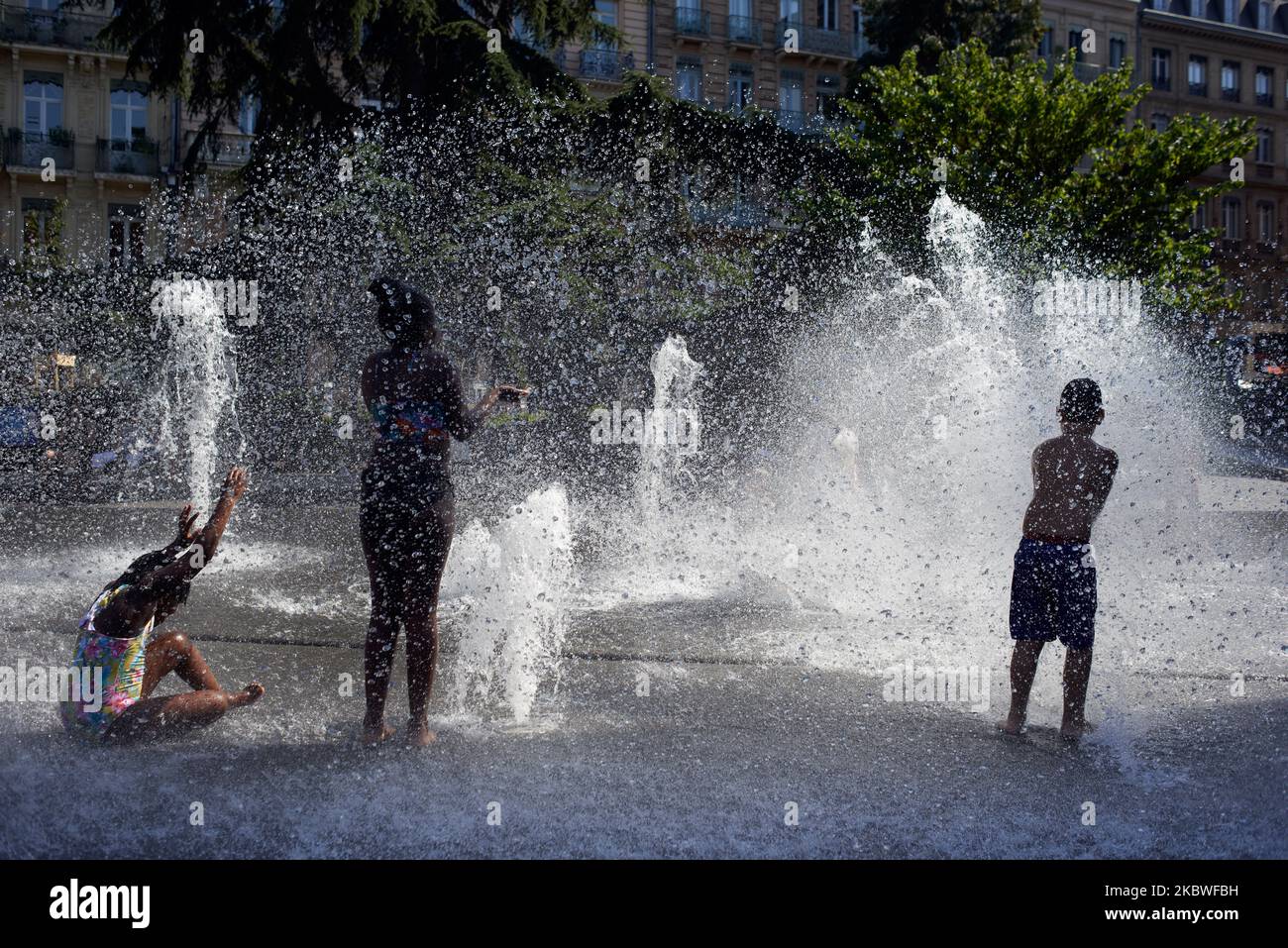 Les enfants jouent dans une fontaine publique dans le centre de Toulouse, juste derrière la mairie. Un pic de chaleur est en France pendant deux jours au moins. À Toulouse, les températures ont atteint 36°C à 5pm. Plusieurs enregistrements de température ont été rompus sur la côte atlantique et dans les Pyrénées. Le service météorologique national (Meteofrance) prévoit des températures record dans plusieurs endroits en France. Ce pic de chaleur sera court mais très intense. Toulouse. France. 30 juillet 2020. (Photo d'Alain Pitton/NurPhoto) Banque D'Images