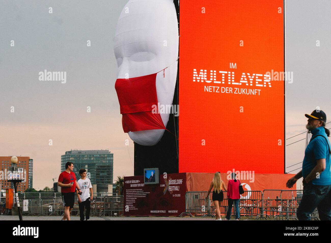 Les gens se promène devant l'installation d'art vidéo « visages de Düsseldorf » à Düsseldorf, en Allemagne, sur 13 août 2020. (Photo de Ying Tang/NurPhoto) Banque D'Images