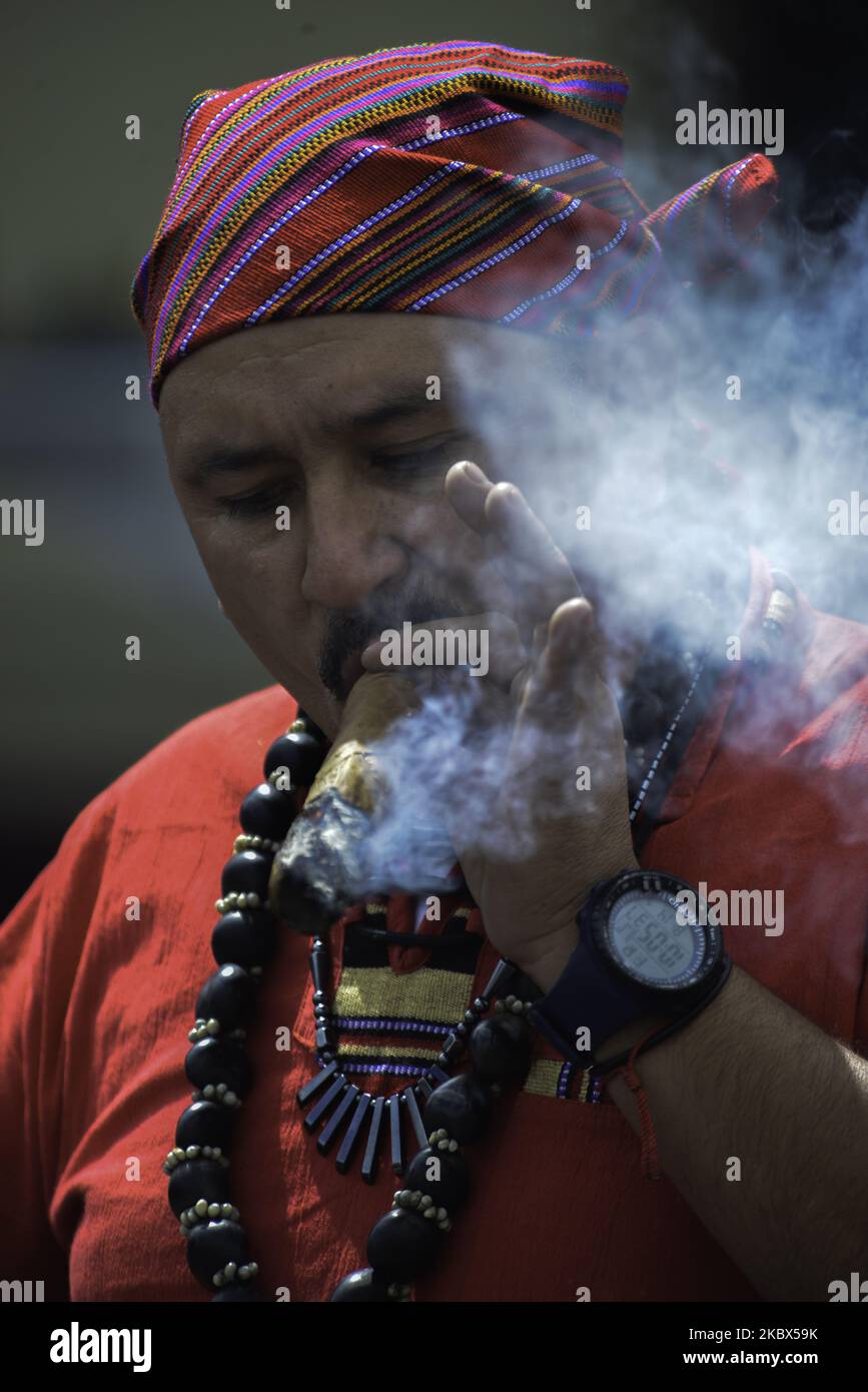 Un autochtone fume un cigare à l'extérieur du temple lors de sa cérémonie à Saint Simon au temple de San Andrés Itzapa, à 50 kilomètres à l'ouest de la ville de Guatemala, sur 14 août 2020. Des milliers de personnes croient que le saint qui aide les gens à trouver du travail, résout les problèmes familiaux et guérit les maladies. Pendant la pandémie, le temple a été fermé pour prévenir la contagion, avec un total de 61 428 personnes infectées et 2 341 morts dans tout le pays. (Photo de Deccio Serrano/NurPhoto) Banque D'Images