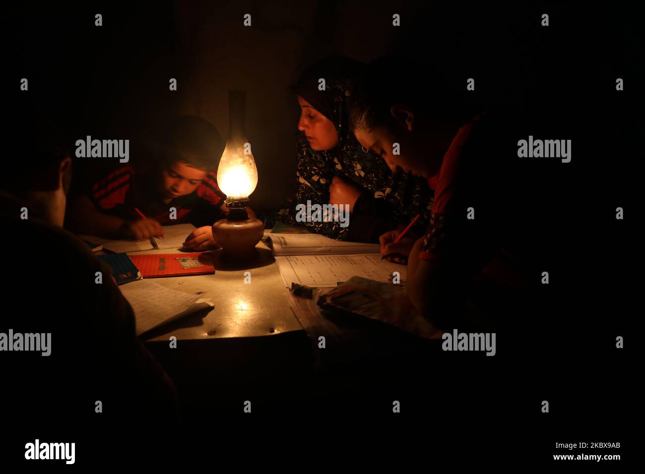 Les enfants palestiniens font leur travail à domicile en utilisant des lampes à gaz lors d'une coupure de courant après la fermeture de la seule centrale électrique de Gaza en raison de tensions avec Israël, à Khan Yunis, dans le sud de la bande de Gaza, au 18 août 2020. (Photo de Majdi Fathi/NurPhoto) Banque D'Images