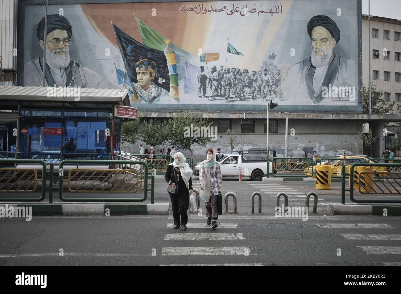 Deux femmes iraniennes portant un masque facial protecteur traversent une avenue en se promenant sous des portraits du Guide suprême de l'Iran, l'ayatollah Ali Khamenei (L) et de feu le dirigeant, l'ayatollah Ruhollah Khomeini, dans le quartier des affaires de Téhéran, au milieu du nouveau coronavirus (COVID-19) qui a éclaté en Iran, sur 5 juillet 2020. (Photo de Morteza Nikoubazl/NurPhoto) Banque D'Images