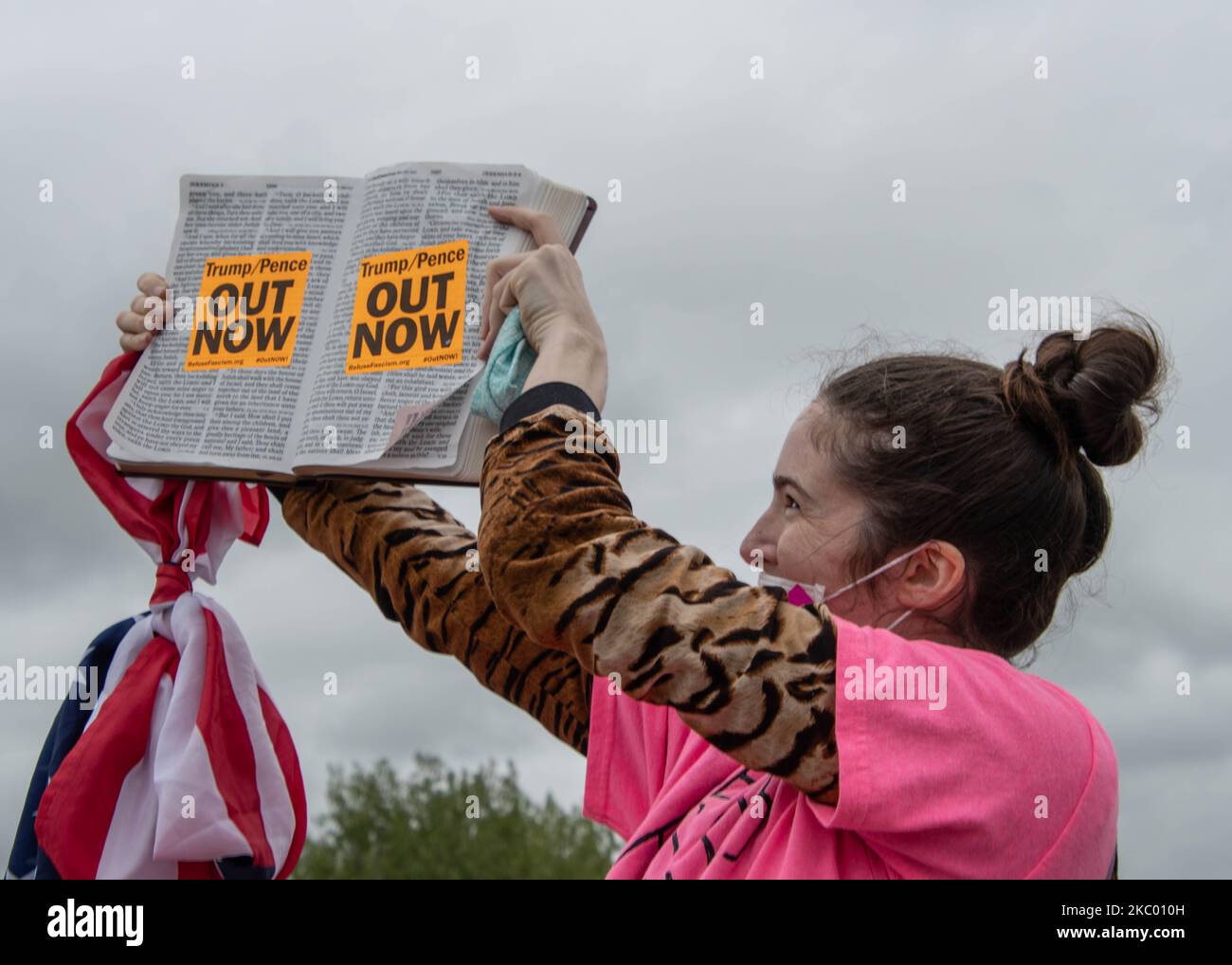 Un contre-manifestant détient une bible contenant des autocollants « Trump Pence Out Now » lors du rassemblement de Trump organisé à l'aéroport international MBS de Freeland, Michigan, sur 10 septembre 2020. (Photo par Adam Dewey/NurPhoto) Banque D'Images