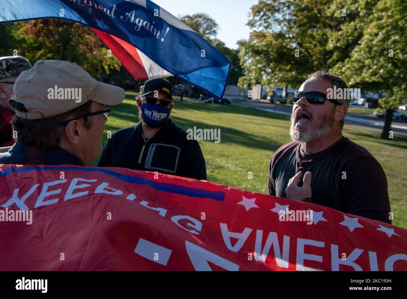 Un partisan de Trump (à gauche) soutient un partisan de Biden (à droite) après la fin de la campagne de Biden-Harris 2020. Bernie Sanders a organisé un rassemblement de campagne pour soutenir Joe Biden et Kamala Harris au Collège communautaire de Macomb à Warren, Michigan, sur 5 octobre 2020. Le rallye de style drive-in a permis aux centaines de supporters présents de prendre des distances sociales sûres en ce qui concerne les préoccupations relatives à la COVID-19. Les manifestants pro-Trump se sont organisés juste en dehors du rassemblement officiel de la campagne Biden-Harris pour montrer leur opposition aux diverses plates-formes démocratiques. Le comté de Macomb, est considéré comme un terrain de bataille crucial Banque D'Images