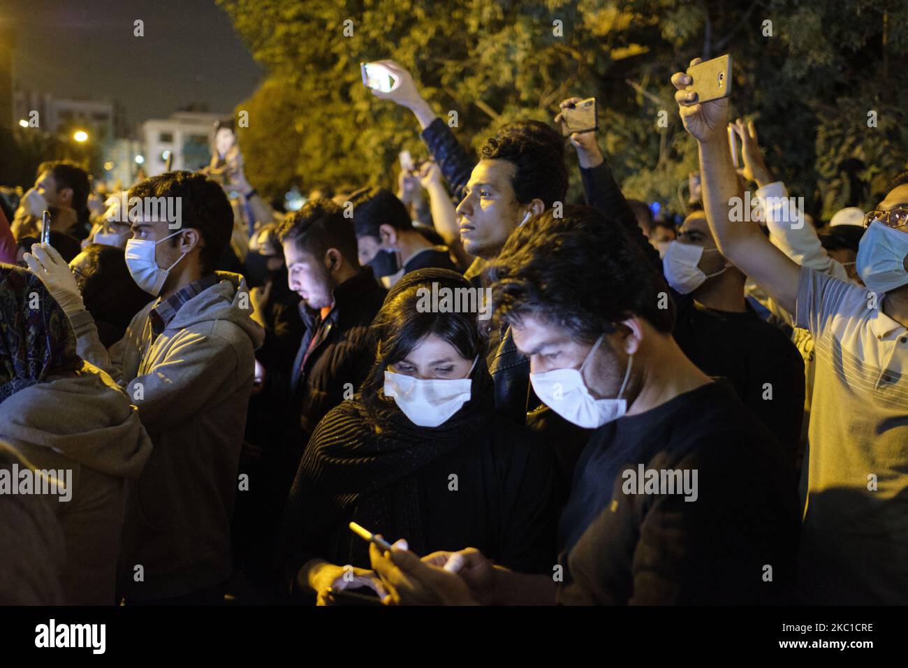 Une femme et un homme iraniens utilisent leur smartphone tout en