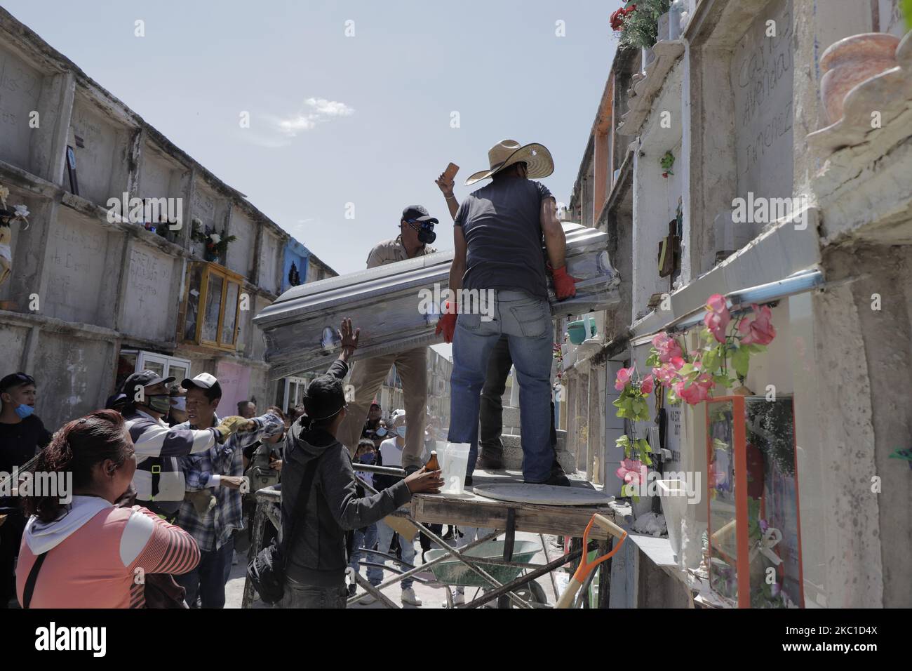 Les Gravediggers entrent dans un cercueil avec le corps d'une personne décédée dans un tiroir du Panthéon municipal de Nezahualcóyotl, Etat du Mexique. Le panthéon continue d'offrir des services funéraires pour des causes naturelles ou COVID-19, soit pour l'enterrement, soit pour la crémation. Au Mexique, les chiffres confirmés par le ministère de la Santé la nuit de 7 octobre, il y a 774 020 cas confirmés accumulés par le COVID-19, 80 083 décès et 560 895 reprises estimées. Sur 8 octobre 2020 à Nezahualcóyotl, Mexique. (Photo de Gerardo Vieyra/NurPhoto) Banque D'Images