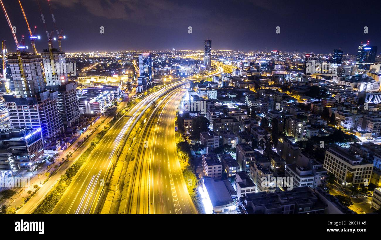 Vue aérienne nocturne de tel aviv avec gratte-ciel urbains et feux arrière longue exposition sur l'autoroute ayalon, Israël Banque D'Images