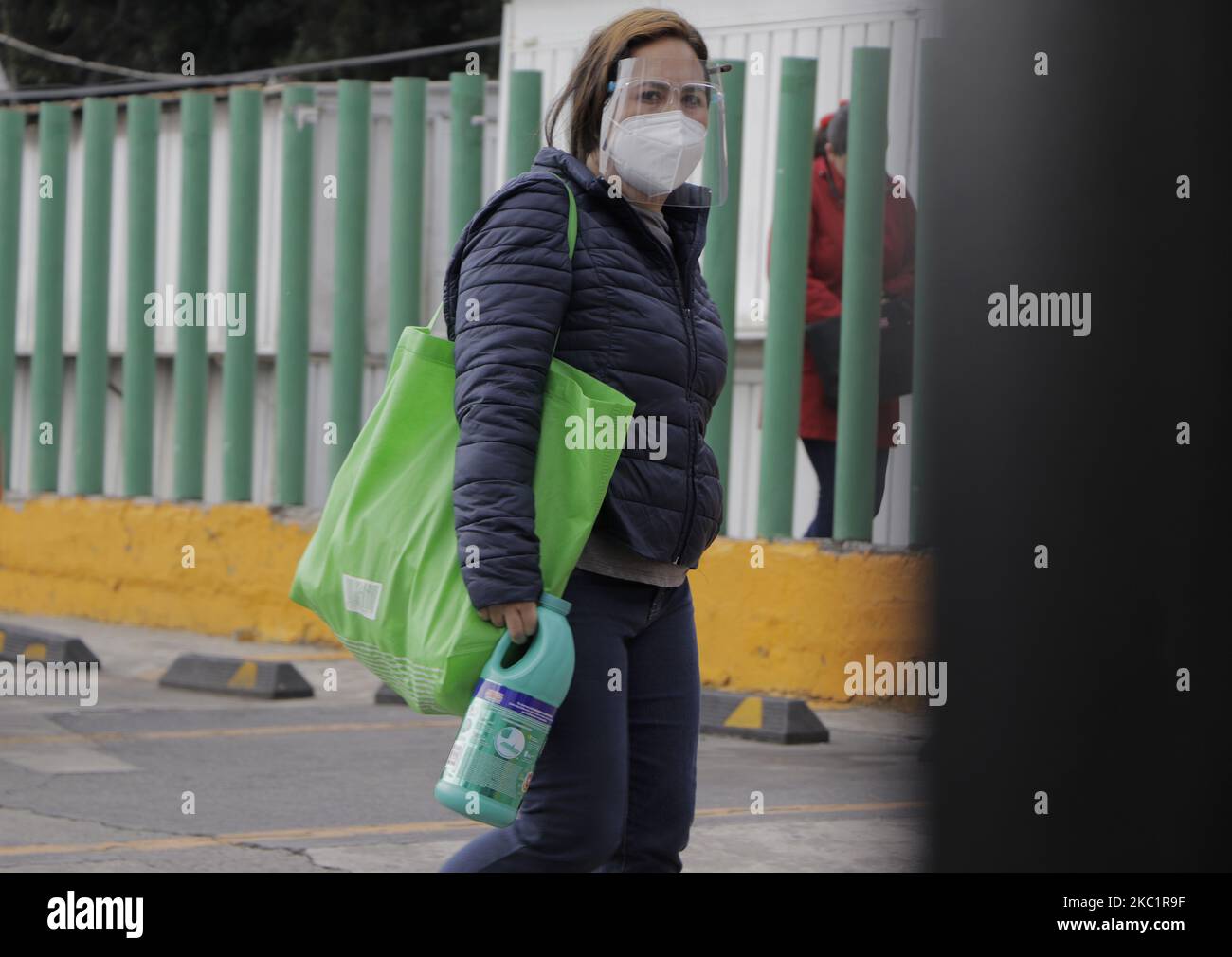 Un passant muni d'un masque de protection et d'une bouteille de chlore, se promène devant un kiosque sanitaire installé à Colonia Lomas Estrella, Iztapalapa, reçoit des moyens pour l'application de tests libres pour la détection de COVID-19 dans le cadre du programme attention prioritaire aux colonies, Villes et quartiers de Mexico. Sur 13 octobre 2020 à Mexico, Mexique. (Photo de Gerardo Vieyra/NurPhoto) Banque D'Images