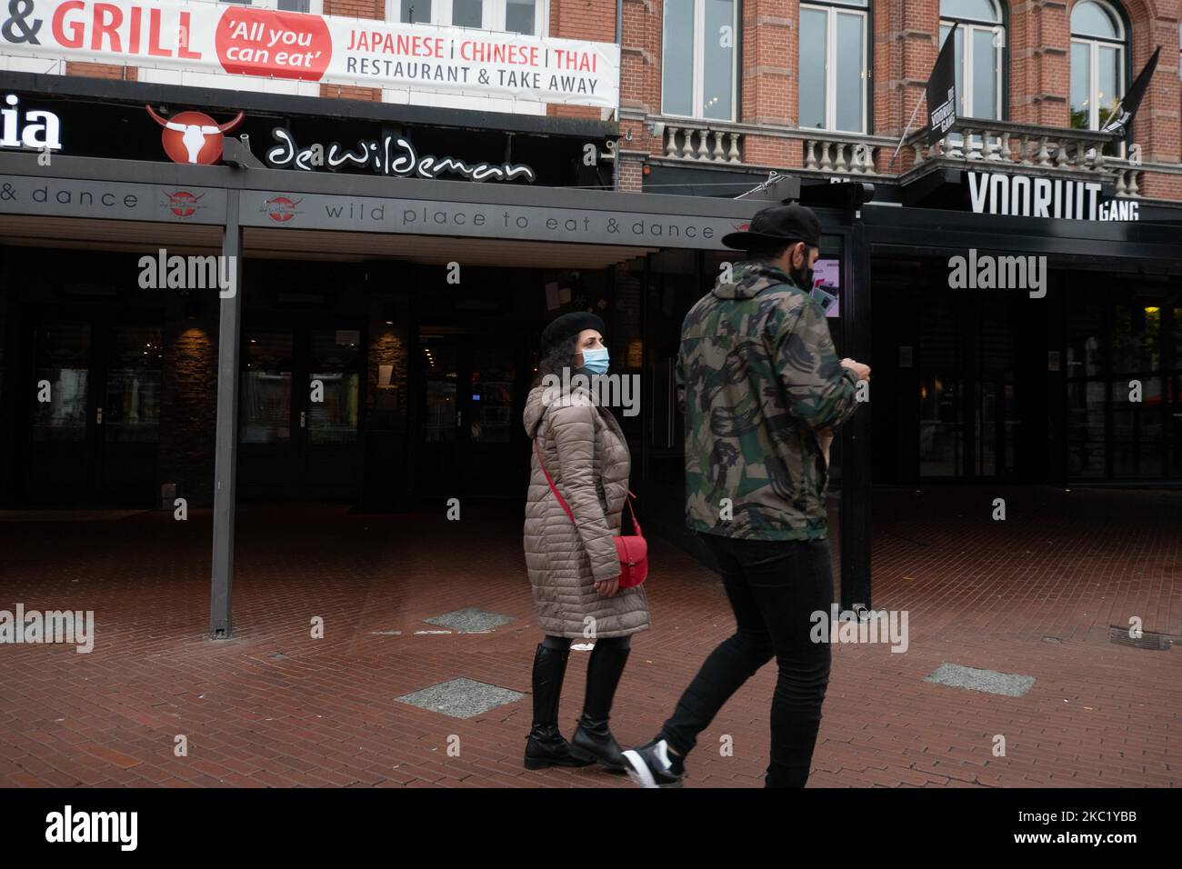 Les gens d'Eindhoven passent devant des cafés et des bars fermés pendant le confinement partiel et la vie quotidienne dans la ville d'Eindhoven aux pays-Bas avec des gens portant un masque facial lorsqu'ils sont à l'extérieur ou à vélo comme mesure de protection contre la propagation de l'épidémie de coronavirus Covid-19. Le mardi 13 octobre 2020, le Premier ministre néerlandais Mark Rutte a annoncé que les pays-Bas doivent revenir à un verrouillage partiel, la fermeture des bars, cafés et restaurants, l'utilisation obligatoire du masque facial à l'intérieur, la limitation au nombre de personnes se rassemblent à l'intérieur, les activités sportives et plus sont également un Banque D'Images