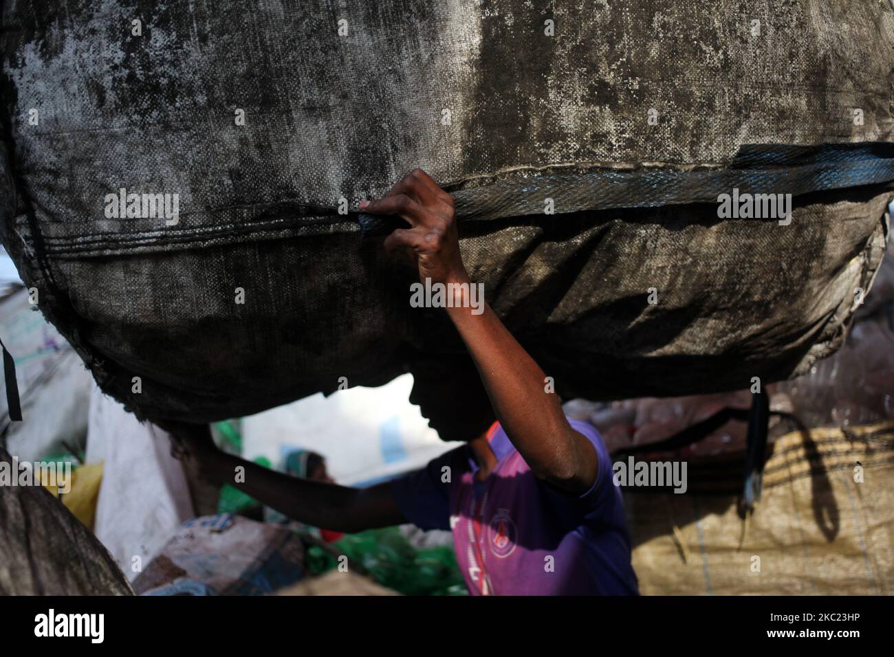 Un travailleur transporte une bouteille en plastique triée pour transformation ultérieure dans une usine de recyclage de plastique à Dhaka, au Bangladesh, samedi, à 17 octobre 2020. (Photo de Syed Mahamudur Rahman/NurPhoto) Banque D'Images Un travailleur transporte une bouteille en plastique triée pour transformation ultérieure dans une usine de recyclage de plastique à Dhaka, au Bangladesh, samedi, à 17 octobre 2020. (Photo de Syed Mahamudur Rahman/NurPhoto) Banque D'Images