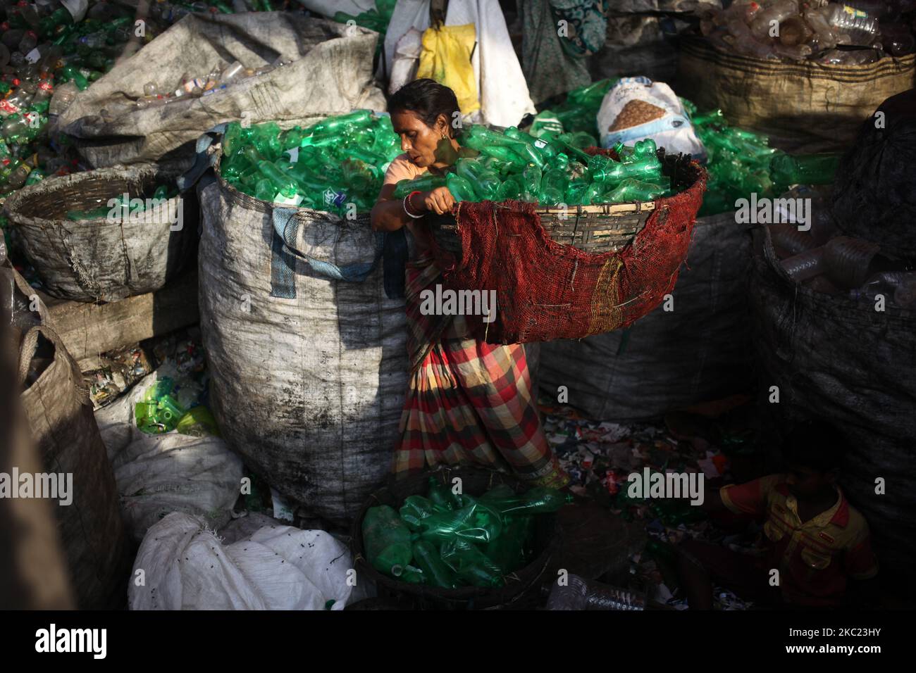 Une travailleuse porte une bouteille en plastique triée pour transformation ultérieure dans une usine de recyclage de plastique à Dhaka, au Bangladesh, samedi, à 17 octobre 2020. (Photo de Syed Mahamudur Rahman/NurPhoto) Banque D'Images