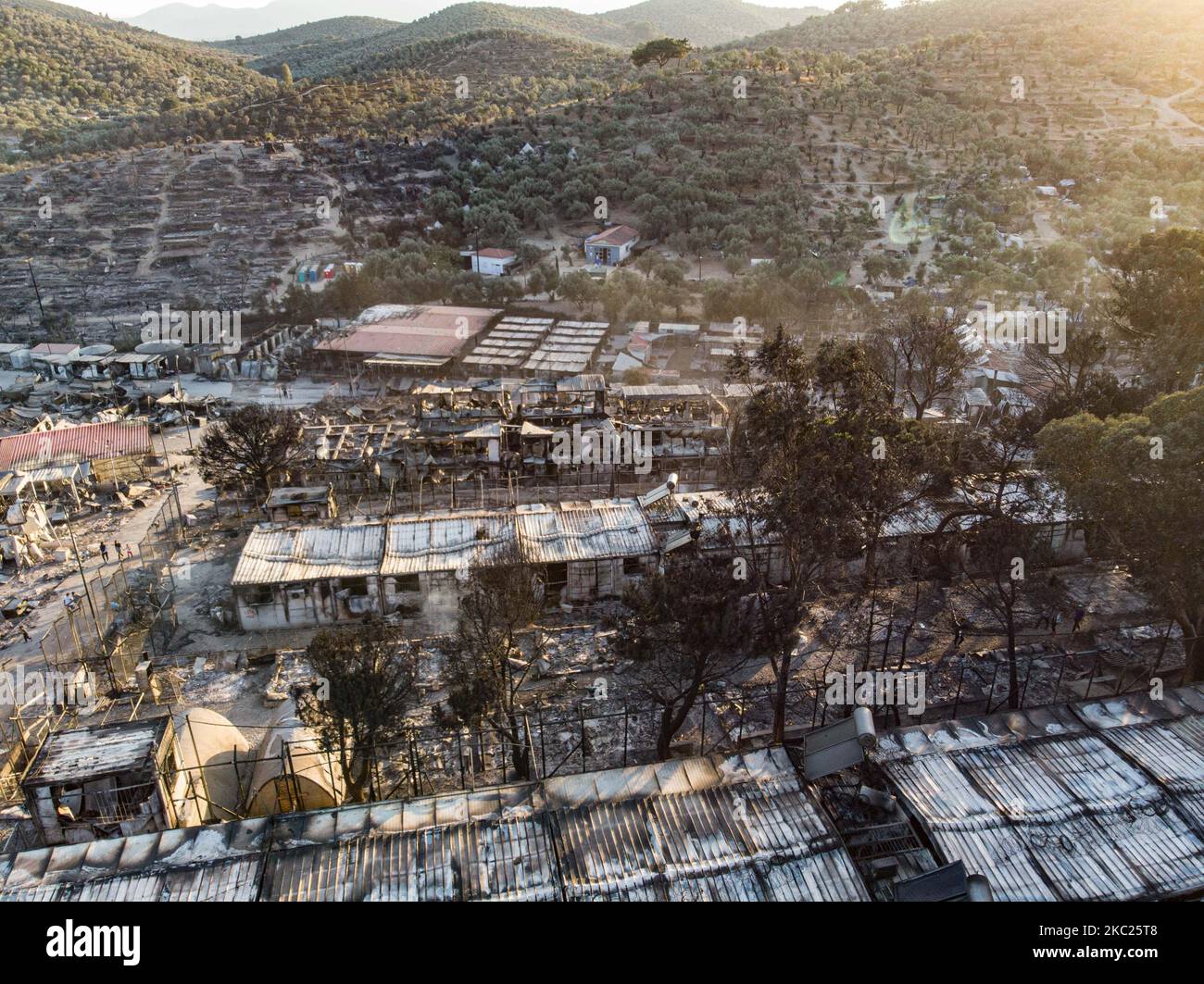 Vue panoramique depuis un drone des suites du premier incendie dans le camp de réfugiés de Moria et les oliveraies voisines. Des milliers de demandeurs d'asile ont vécu après l'incendie sur le bord de la route dans des tentes de fortune, ont été transférés au nouveau camp de réfugiés à Kara Tepe - Mavrovouni, une ancienne zone militaire, champ de tir de l'armée hellénique, près de la ville de Mytilène dans l'île de Lesbos en Grèce. Le nouveau camp temporaire Kara Tepe a été créé après le feu de 9 septembre 2020, lorsque l'un des plus grands camps de réfugiés d'Europe, Moria hotspot (centre d'accueil, d'identification et d'enregistrement) a été brûlé. Al Banque D'Images