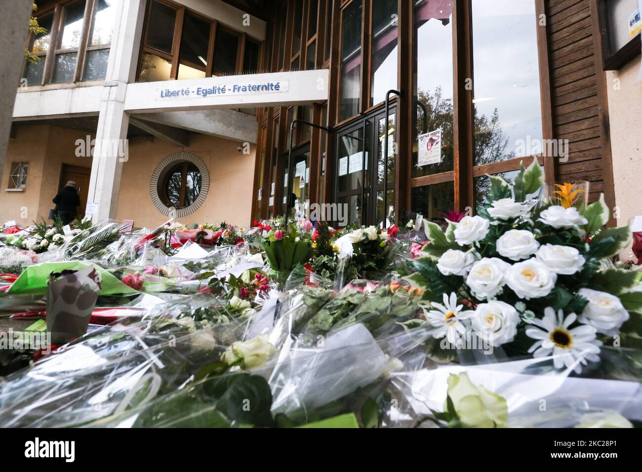 Des fleurs sont placées à l'extérieur de l'école secondaire Bois d'Aulne en hommage au professeur d'histoire assassiné Samuel Paty, qui a été décapité par un attaquant pour avoir montré des dessins animés du prophète Mahomet dans sa classe civique, sur 19 octobre 2020, à Conflans-Sainte-Honorine, au nord-ouest de Paris. Paty, âgé de 47 ans, a été attaqué sur 16 octobre à son retour du lycée où il a enseigné par Abdullakh Anzorov, un tchétchène de 18 ans, qui a été abattu par la police. Après l'attaque, des dizaines de milliers de personnes ont pris part à des rassemblements à l'échelle nationale pour honorer Paty et défendre la liberté d'expression. (Photo de mi Banque D'Images