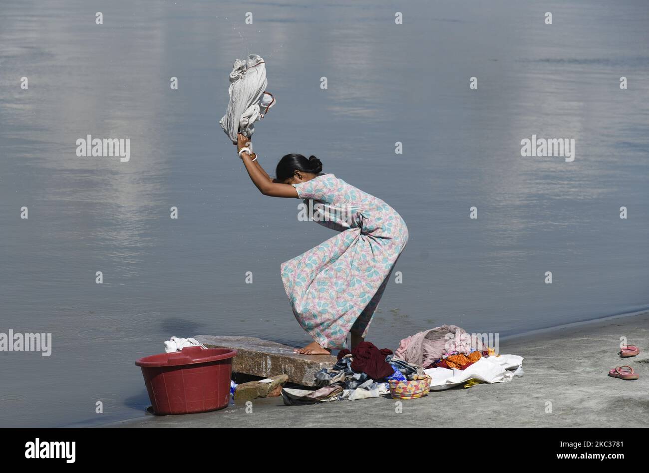 Une femme lavant ses vêtements sur les rives du fleuve Brahmaputra, à Guwahati, en Inde, le 02 novembre 2020. (Photo de David Talukdar/NurPhoto) Banque D'Images