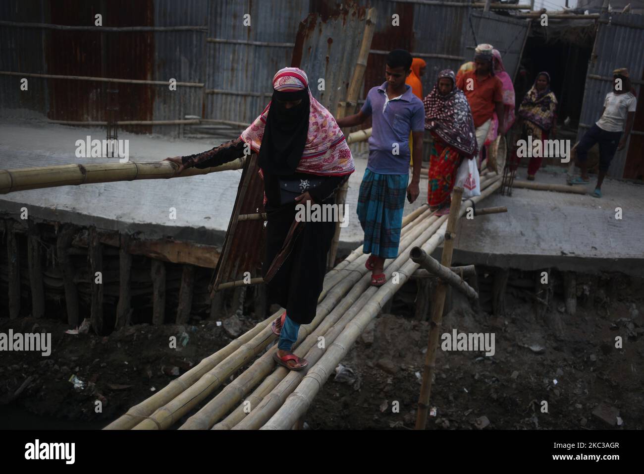 Les gens traversent un pont en bambou dans la région de Hazaribagh à Dhaka, au Bangladesh, le mercredi, 04 novembre 2020. (Photo de Syed Mahamudur Rahman/NurPhoto) Banque D'Images Les gens traversent un pont en bambou dans la région de Hazaribagh à Dhaka, au Bangladesh, le mercredi, 04 novembre 2020. (Photo de Syed Mahamudur Rahman/NurPhoto) Banque D'Images