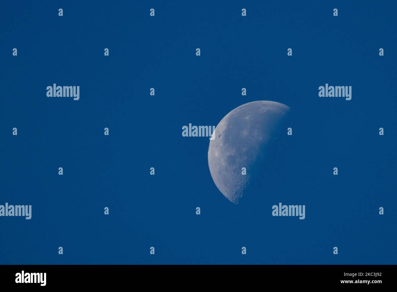 La Lune vue des pays-Bas dans le ciel bleu. La phase Lune ou Luna est à un troisième quart avec le côté gauche illuminé environ 51% comme vu de l'hémisphère nord de la terre. La Lune est le satellite naturel de la Terre en orbite et l'objet céleste le plus proche de l'univers. Eindhoven, pays-Bas sur 8 novembre 2020 (photo de Nicolas Economou/NurPhoto) Banque D'Images