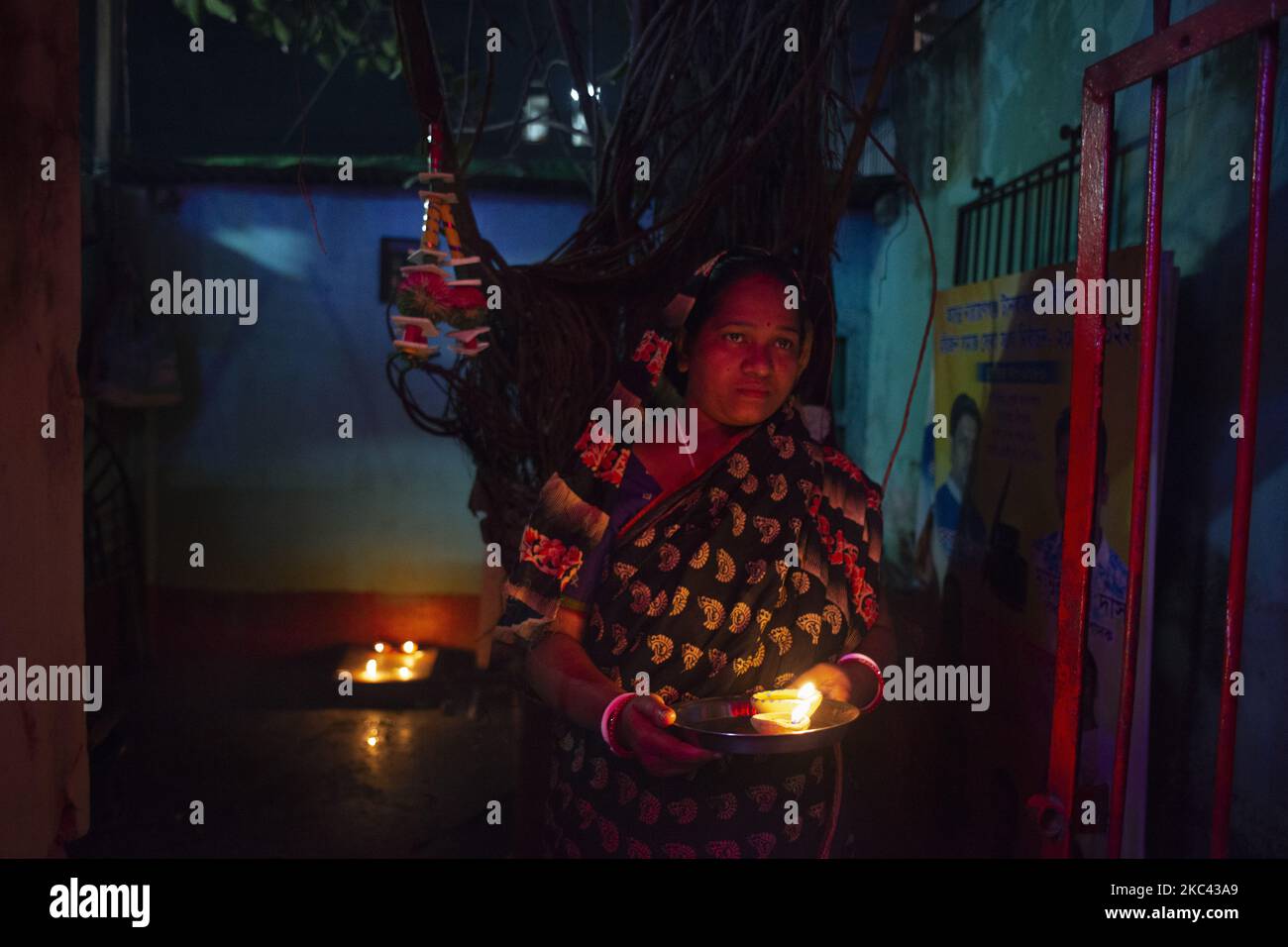 Une femme tenant des lampes à huile à l'extérieur de sa maison tout en célébrant Diwali à Narayanganj, au Bangladesh, sur 15 novembre 2020. (Photo par Ziaul Haque/NurPhoto) Banque D'Images