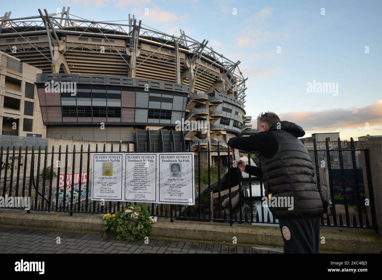 Un homme prend une photo d'affiches avec les noms des vicejours sanglants  du dimanche à la clôture à l'extérieur de Croke Park à Dublin, lors d'un  événement de commémoration organisé par les "