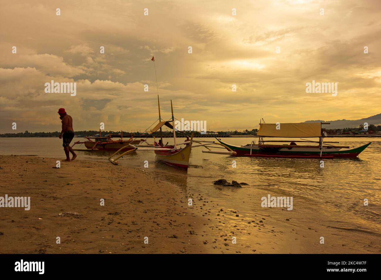 Bateaux traditionnels, pêcheurs, coucher de soleil et plage à Halmahera, Nord de Maluku, Indonésie. Banque D'Images