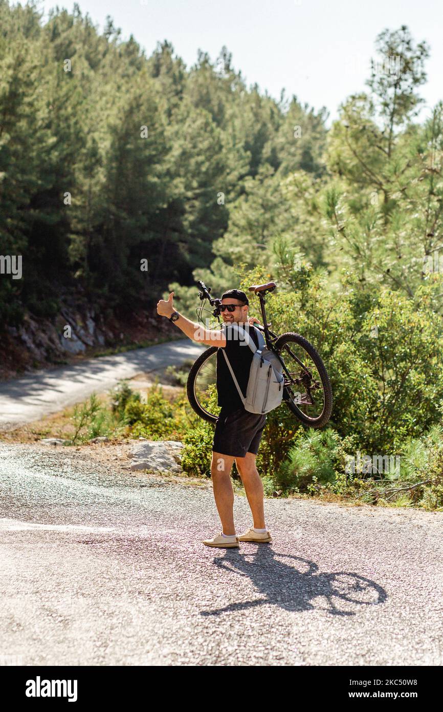 Un homme voyage à travers les montagnes de la Turquie sur un vélo par une journée ensoleillée Banque D'Images