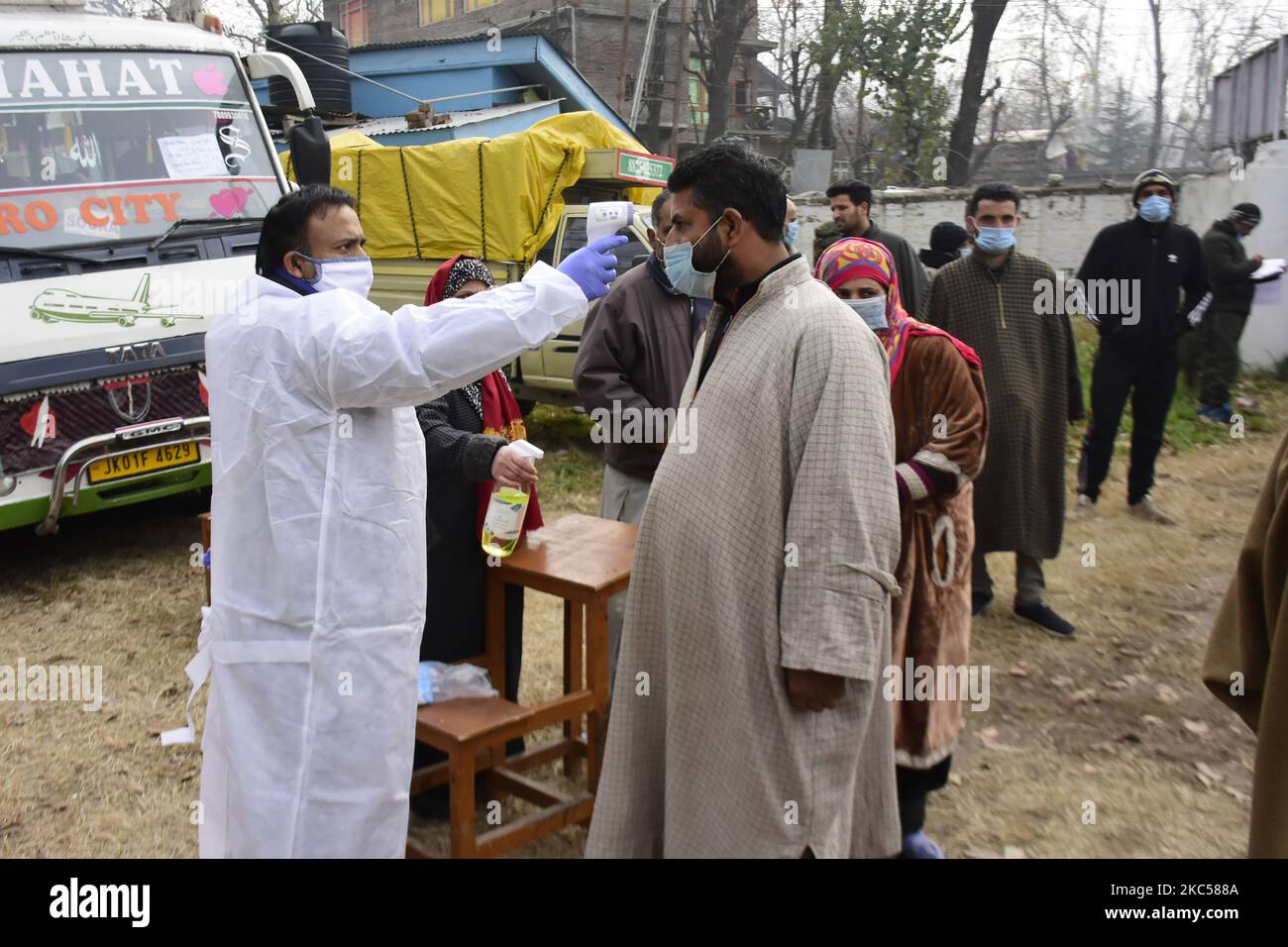 Les responsables de la santé vérifient la température à l'extérieur du stand de vote en durant la troisième phase de DDC, élections ULP dans le district de Ganderbal, dans le Cachemire administré par l'Inde le 04 décembre 2020. Troisième phase du conseil de développement du district, l'élection des organes locaux urbains a eu lieu dans de nombreuses constuiences à travers Jammu et Cachemire. (Photo de Muzamil Mattoo/NurPhoto) Banque D'Images