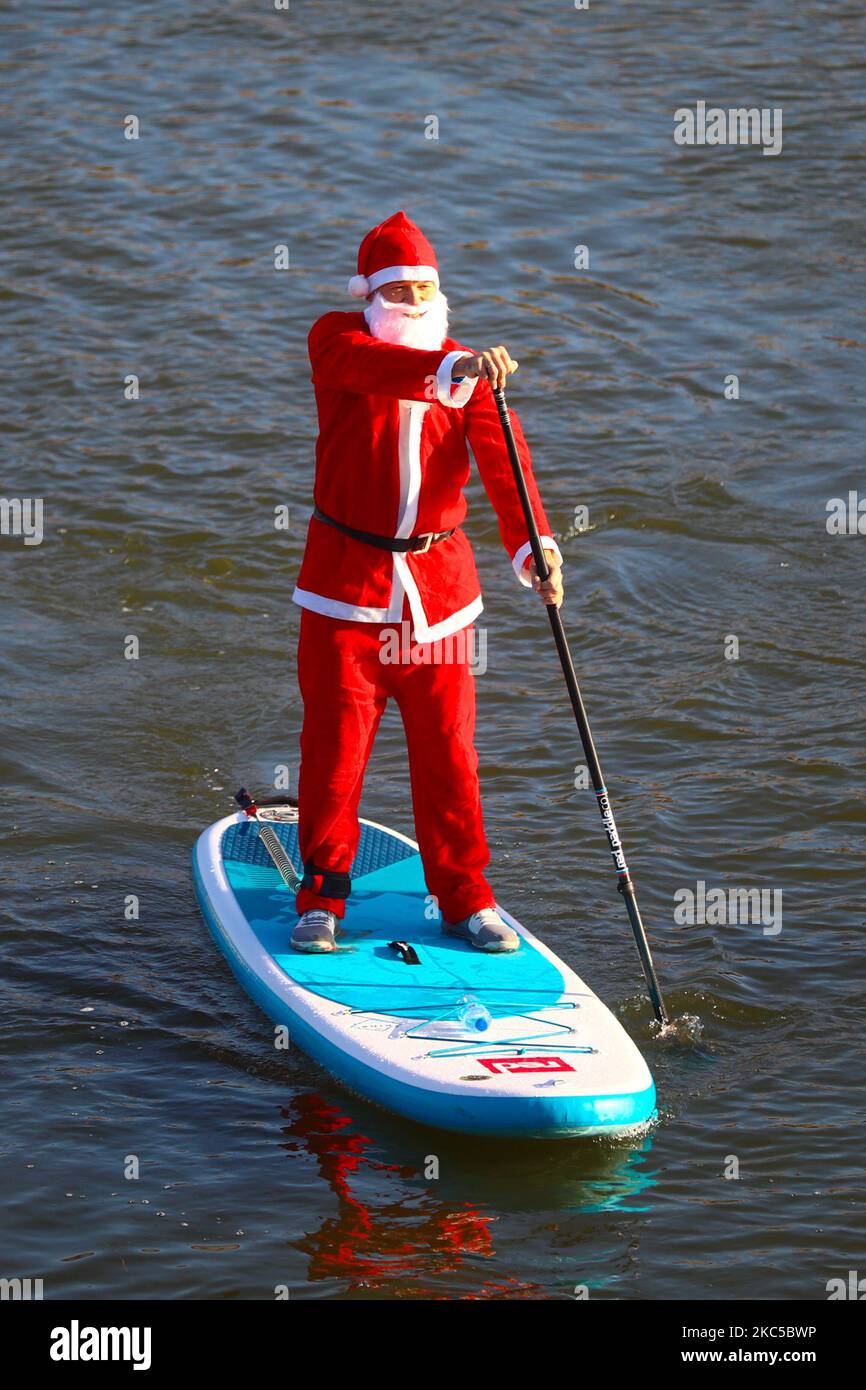 Les surfeurs en paddleboard vêtus des costumes du Père Noël flottent sur la Vistule lors d'un événement caritatif le jour de Saint Nicolas à Cracovie, en Pologne. 6 décembre 2020. (Photo de Beata Zawrzel/NurPhoto) Banque D'Images