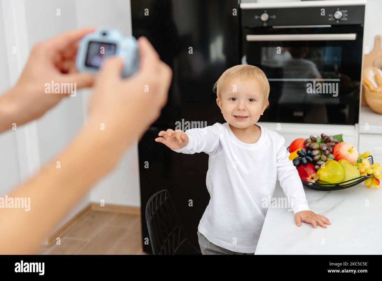 Une mère prend une photo de son bébé avec un appareil photo de bébé jouet Banque D'Images