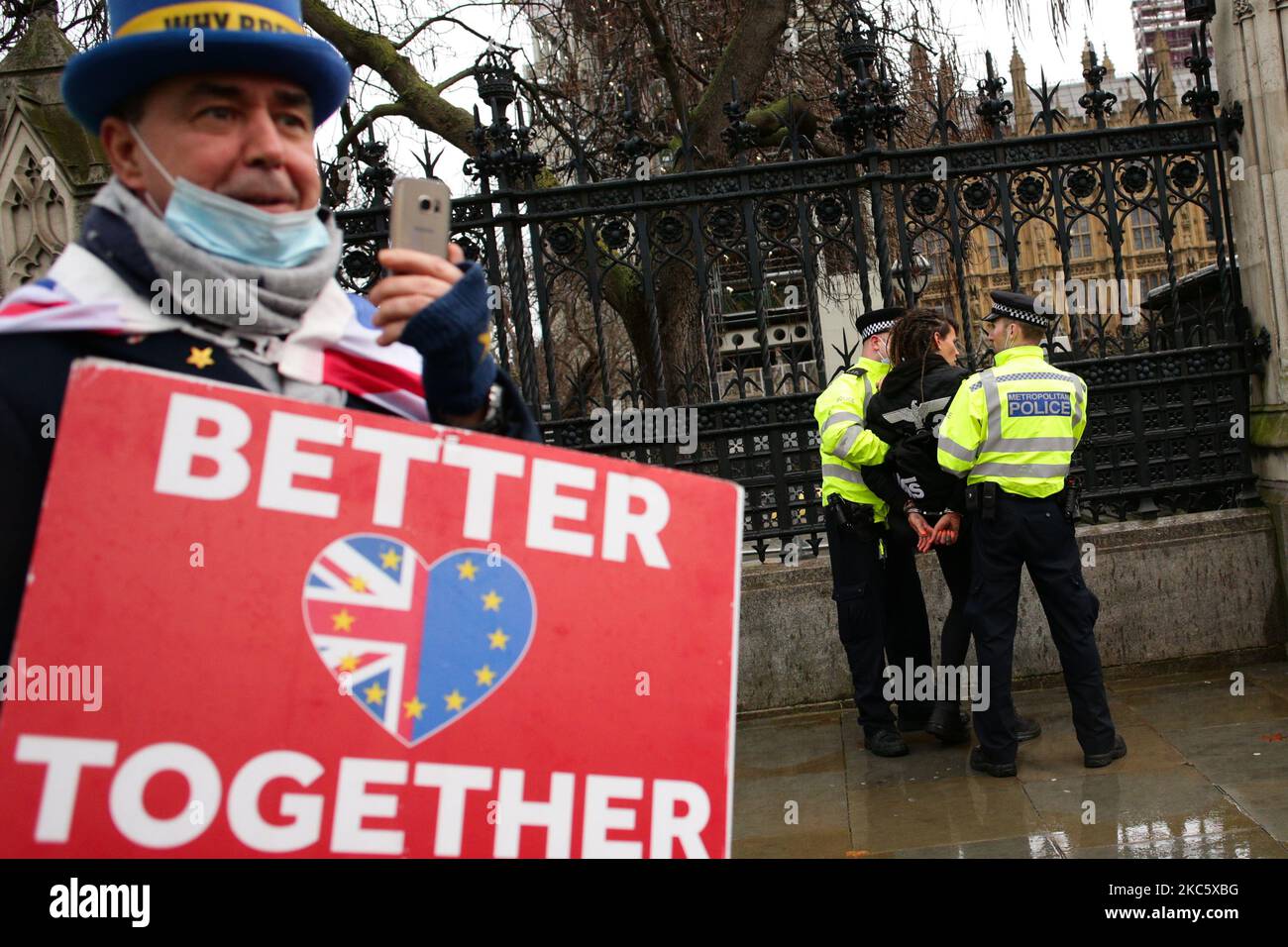 Le militant anti-Brexit Steve Bray regarde comme un militant protestant contre les restrictions de verrouillage du coronavirus et toute vaccination obligatoire contre le covid-19 est arrêtée par des policiers sur la place du Parlement à Londres, en Angleterre, sur 14 décembre 2020. Londres doit être mutée vers les restrictions de niveau 3, indiquant un niveau d'alerte de coronavirus très élevé, à partir de ce mercredi, exigeant la fermeture de pubs, bars, cafés et restaurants autres que d'offrir un service de livraison et de plats à emporter. La ville a été retournée à la catégorie 2, ou alerte « élevée », restrictions à la fin de la période de quatre semaines de confinement à l'échelle de l'Angleterre sur 2 décembre, bien que W Banque D'Images