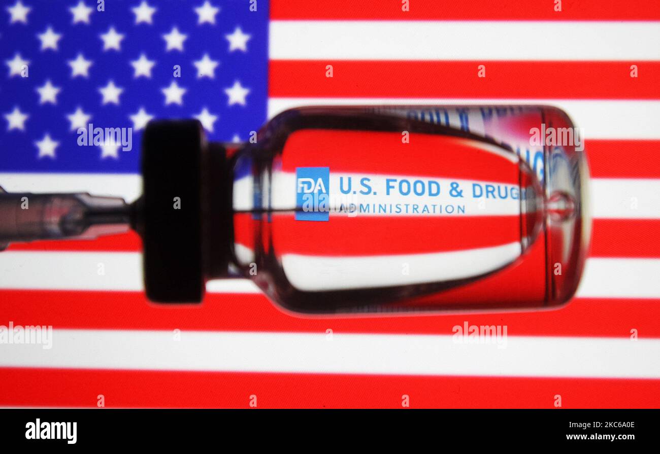 Une seringue médicale et un flacon sont vus devant le logo de la Food and Drug Administration (FDA) des États-Unis et le drapeau américain dans cette photo d'illustration créative. La FDA a autorisé le vaccin contre le coronavirus Moderna COVID-19 pour une utilisation d'urgence, comme indiqué précédemment par les médias. (Illustration par STR/NurPhoto) Banque D'Images