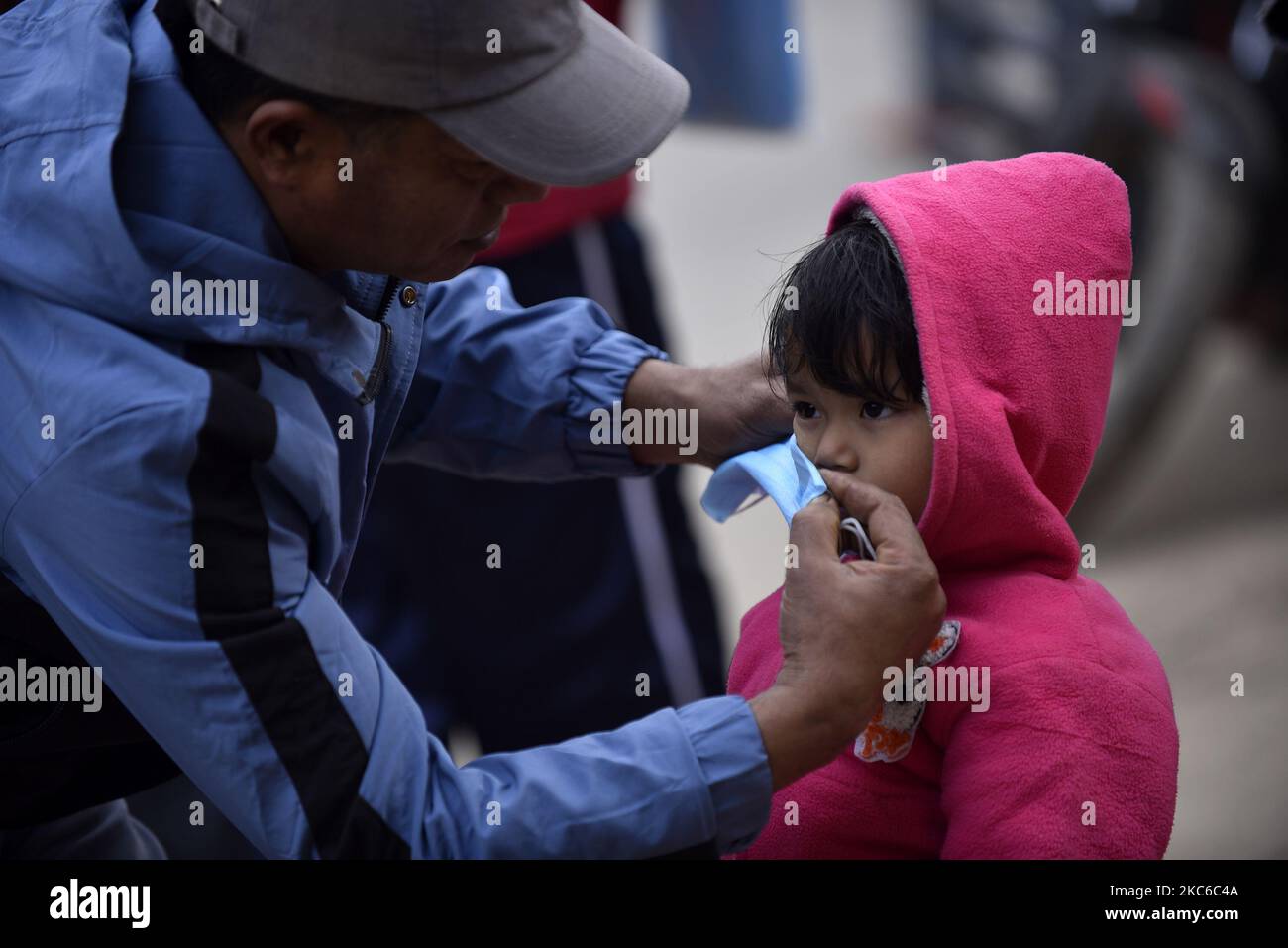 Un volontaire pour aider à mettre des masques sur le visage des dévotés pendant Saat Gaule Jatra à Panga, Kirtipur, Katmandou, Népal mercredi, 23 décembre, 2020. C'est la partie du célèbre festival célébré chaque année marquant l'arrivée de l'hiver. Jatras et les festivals font partie de la vie de la communauté de Newar. (Photo de Narayan Maharajan/NurPhoto) Banque D'Images
