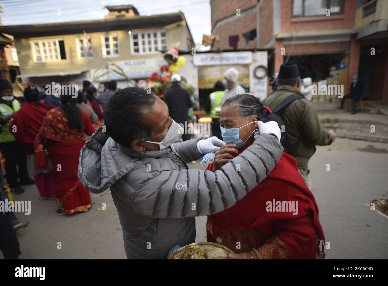 Un volontaire pour aider à mettre des masques sur le visage des dévotés pendant Saat Gaule Jatra à Panga, Kirtipur, Katmandou, Népal mercredi, 23 décembre, 2020. C'est la partie du célèbre festival célébré chaque année marquant l'arrivée de l'hiver. Jatras et les festivals font partie de la vie de la communauté de Newar. (Photo de Narayan Maharajan/NurPhoto) Banque D'Images