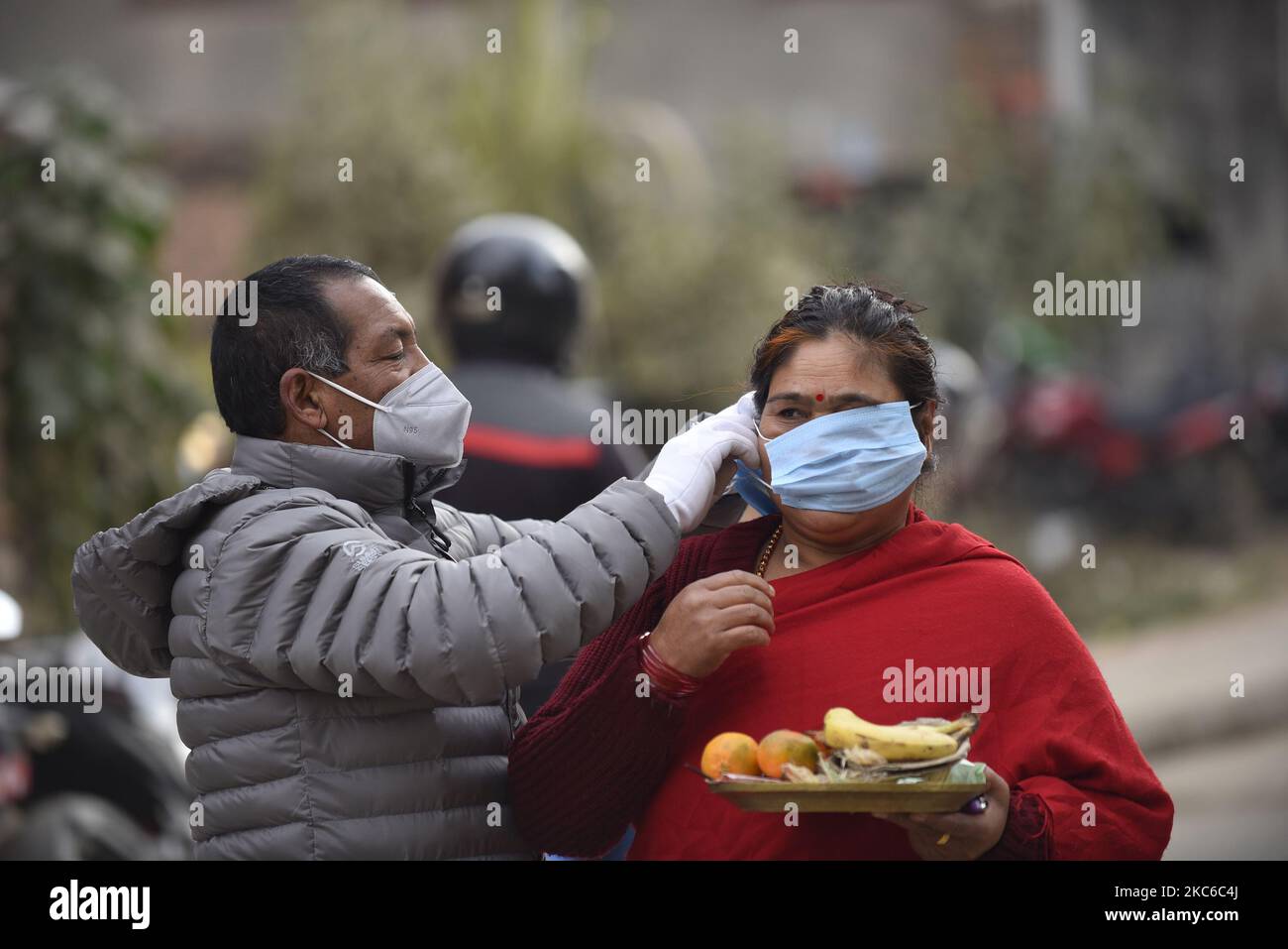 Un volontaire pour aider à mettre des masques sur le visage des dévotés pendant Saat Gaule Jatra à Panga, Kirtipur, Katmandou, Népal mercredi, 23 décembre, 2020. C'est la partie du célèbre festival célébré chaque année marquant l'arrivée de l'hiver. Jatras et les festivals font partie de la vie de la communauté de Newar. (Photo de Narayan Maharajan/NurPhoto) Banque D'Images