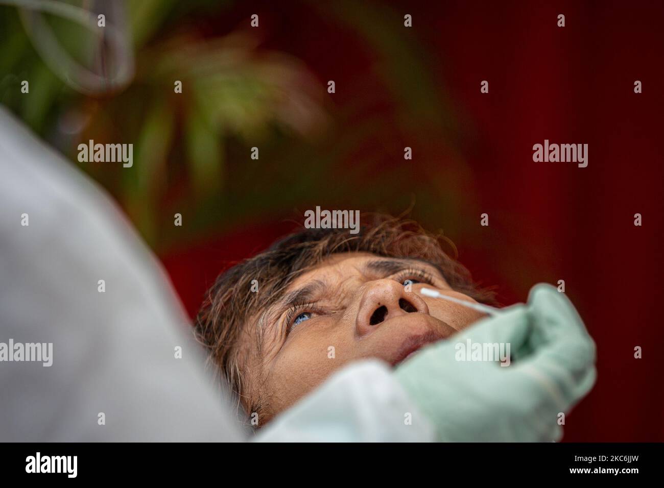 Un professionnel de la santé indonésien prélève un écouvillon auprès de personnes vivant chez un piéton lors des opérations Humanity à Jakarta, Indonésie, le 29 décembre 2020. Selon les données publiées par le Ministère de la santé, l'Indonésie a enregistré plus de sept cent mille cas de COVID-19 depuis le début de la pandémie. Le gouvernement indonésien fermera ses frontières à tous les visiteurs étrangers du 01 au 14 janvier 2021 afin de lutter contre la propagation de la maladie infectieuse. (Photo par Afriadi Hikmal/NurPhoto) Banque D'Images