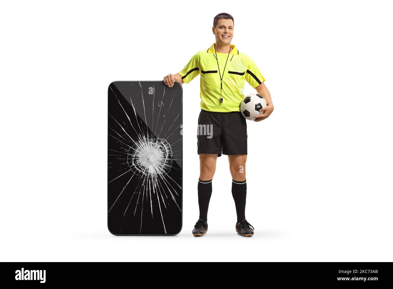 Portrait complet d'un arbitre de football debout à côté d'un smartphone avec écran cassé isolé sur fond blanc Banque D'Images