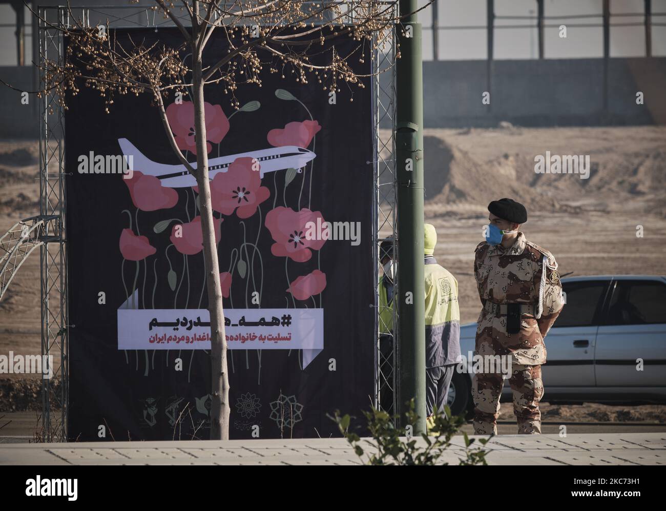 Un membre de la Force terrestre de l'armée iranienne tient une garde à côté d'une bannière lors d'une cérémonie pour marquer l'anniversaire de la mort de l'ancien corps des Gardiens de la révolution islamique (IRGC), Qasem Soleimani et 176 victimes du vol 752, Au cimetière de Behesht-e zahra, au sud de Téhéran, sur 7 janvier 2021. Le vol ukrainien 752 était un vol international régulier de passagers de Téhéran à Kiev sur 8 janvier 2020 qui a abattu peu de temps après le décollage de l'aéroport international Imam Khomeini de Téhéran par le corps de la Garde révolutionnaire islamique (IRGC) et les 176 passagers et l'équipage ont été tués pendant Banque D'Images