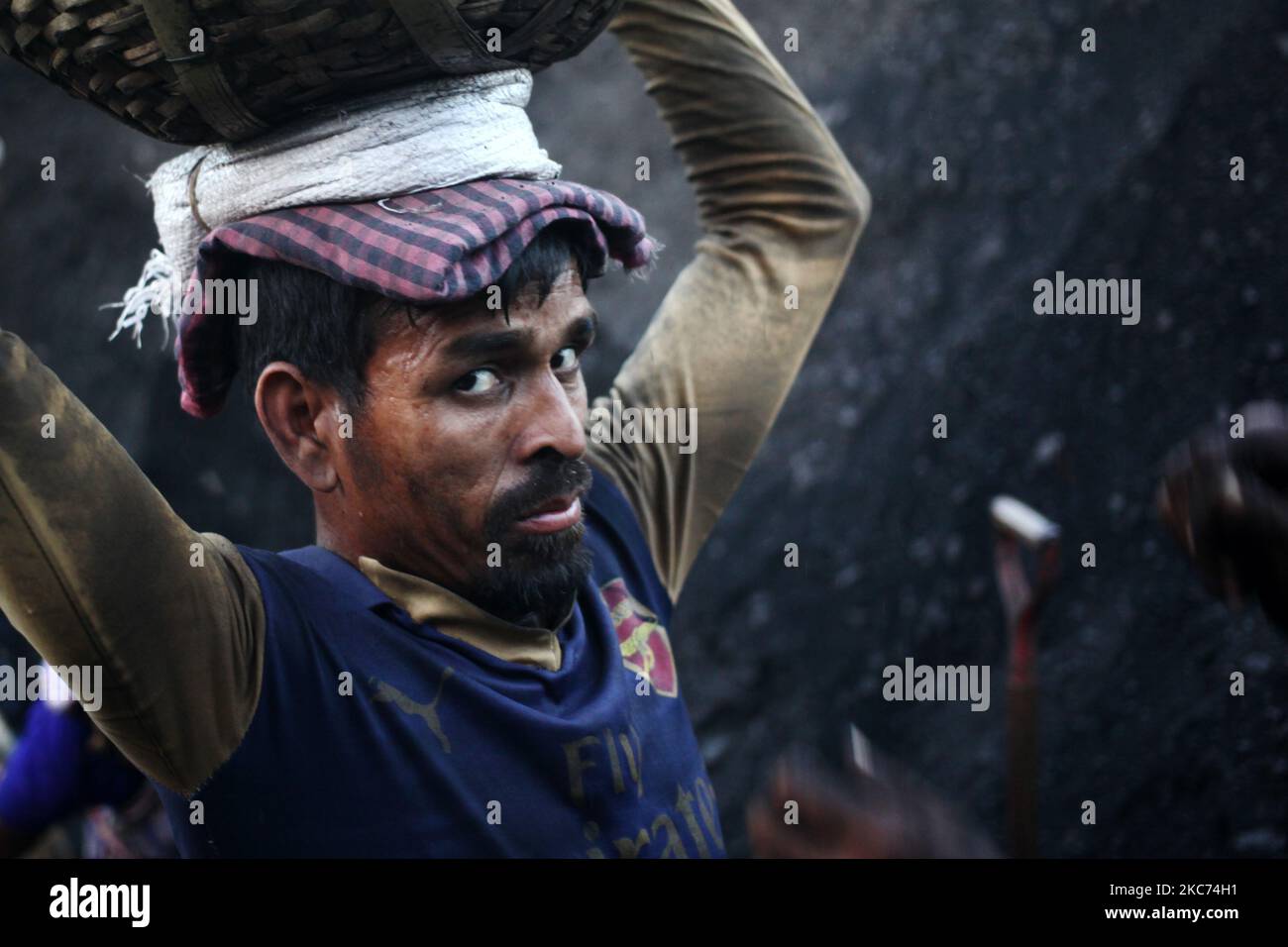 Un travailleur réagit à la caméra lorsqu'il décharge le charbon d'un cargo sur la rive du fleuve Buriganga à Dhaka, au Bangladesh, vendredi, 08 janvier 2021. La consommation actuelle de charbon pour la production d'électricité est d'environ 3,5 millions de tonnes par an pour les deux centrales à charbon du Bangladesh, l'une à Barapukuria (440MW) à Dinajpur et l'autre est la nouvelle centrale Payra (660MW) à Patuakhali. Selon le rapport des médias, si le Plan directeur du secteur de l'énergie 2016 est mis en œuvre, la consommation de charbon pour la production d'électricité serait 10 fois plus en 2030 et 20 fois plus en 2041 que les prs Banque D'Images Un travailleur réagit à la caméra lorsqu'il décharge le charbon d'un cargo sur la rive du fleuve Buriganga à Dhaka, au Bangladesh, vendredi, 08 janvier 2021. La consommation actuelle de charbon pour la production d'électricité est d'environ 3,5 millions de tonnes par an pour les deux centrales à charbon du Bangladesh, l'une à Barapukuria (440MW) à Dinajpur et l'autre est la nouvelle centrale Payra (660MW) à Patuakhali. Selon le rapport des médias, si le Plan directeur du secteur de l'énergie 2016 est mis en œuvre, la consommation de charbon pour la production d'électricité serait 10 fois plus en 2030 et 20 fois plus en 2041 que les prs Banque D'Images