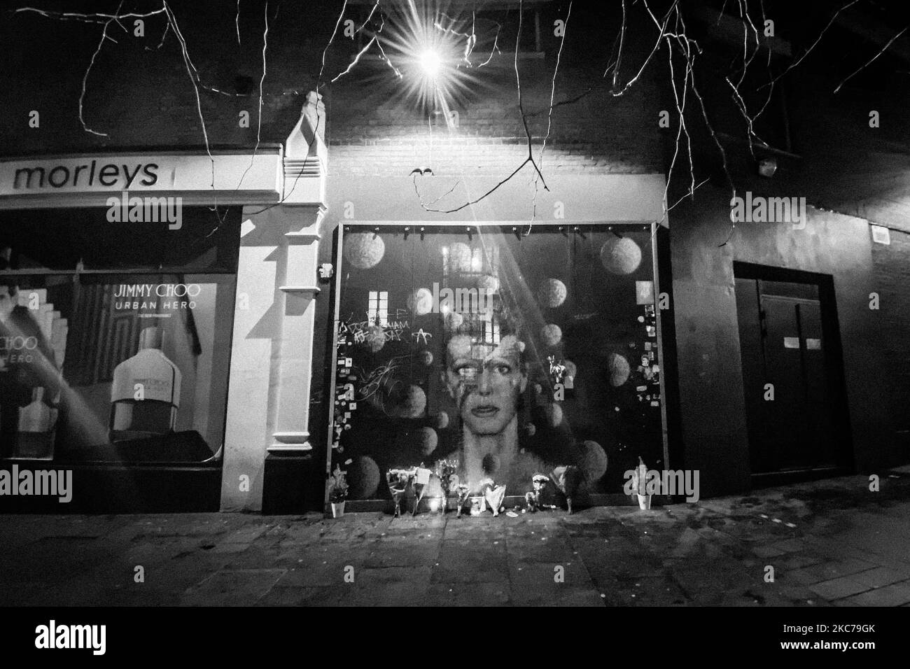 (NOTE DE LA RÉDACTION : l'image a été convertie en noir et blanc) les fleurs et les bougies sont laissées devant une fresque représentant la couverture d'Aladin Sane, pour rappeler le firth anniversaire de la mort du musicien emblématique britannique David Bowie, à Brixton, dans le sud de Londres, sur 10 janvier 2021. David Bowie est mort deux jours seulement après son anniversaire et la reprise de son dernier album, 'Blackstar'. (Photo par Alberto Pezzali/NurPhoto) Banque D'Images