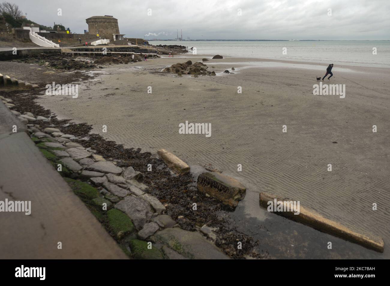 Un homme et son chien courent sur une plage de Seapoint vide à Dublin pendant le verrouillage de niveau 5 Covid-19. L'Irlande a le taux d'infection de Covid-19 le plus élevé au monde après que plus de 45 700 cas ont été enregistrés dans l'État la semaine dernière. Ce soir, le ministère de la Santé a signalé 4 929 nouveaux cas de Covid-19 et 8 décès pour la République d'Irlande. Un nombre record de 1 582 patients Covid-19 étaient à l'hôpital. Le nombre de personnes en soins intensifs est en hausse de 21 à 146. Le lundi 11 janvier 2021, à Dublin, Irlande. (Photo par Artur Widak/NurPhoto) Banque D'Images