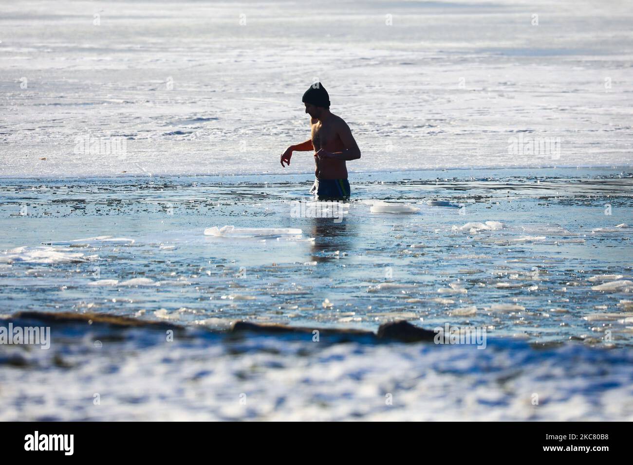 Un nageur d'hiver se délase dans l'eau froide du lac Bagry partiellement gelé à Cracovie, en Pologne, sur 21 janvier 2021. Les restrictions introduites en Pologne en raison de la pandémie du coronavirus ont entraîné la fermeture des piscines publiques, des salles de gym et d'autres centres sportifs. Les fans d'activités physiques qui veulent renforcer leur corps et leur système immunitaire sont de plus en plus disposés à prendre un bain d'hiver dans des réservoirs d'eau froide naturelle. La natation d'hiver est devenue extrêmement populaire parmi les Polonais de tous âges. (Photo de Beata Zawrzel/NurPhoto) Banque D'Images