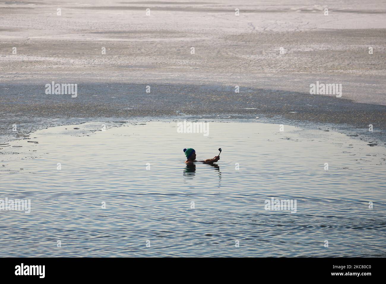 Un nageur d'hiver se délase dans l'eau froide du lac Bagry partiellement gelé à Cracovie, en Pologne, sur 21 janvier 2021. Les restrictions introduites en Pologne en raison de la pandémie du coronavirus ont entraîné la fermeture des piscines publiques, des salles de gym et d'autres centres sportifs. Les fans d'activités physiques qui veulent renforcer leur corps et leur système immunitaire sont de plus en plus disposés à prendre un bain d'hiver dans des réservoirs d'eau froide naturelle. La natation d'hiver est devenue extrêmement populaire parmi les Polonais de tous âges. (Photo de Beata Zawrzel/NurPhoto) Banque D'Images