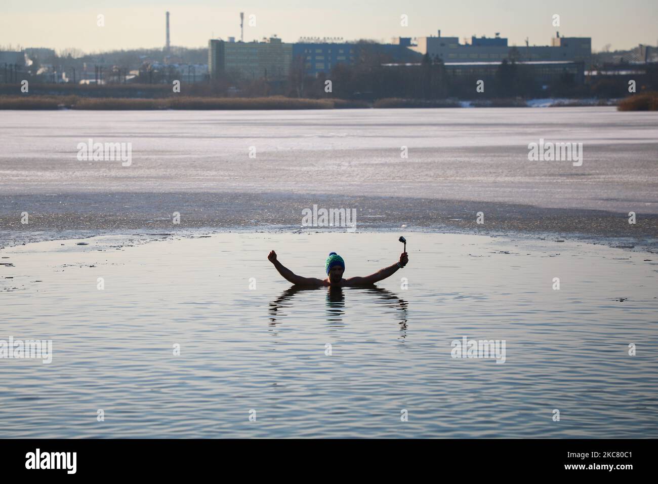 Un nageur d'hiver se délase dans l'eau froide du lac Bagry partiellement gelé à Cracovie, en Pologne, sur 21 janvier 2021. Les restrictions introduites en Pologne en raison de la pandémie du coronavirus ont entraîné la fermeture des piscines publiques, des salles de gym et d'autres centres sportifs. Les fans d'activités physiques qui veulent renforcer leur corps et leur système immunitaire sont de plus en plus disposés à prendre un bain d'hiver dans des réservoirs d'eau froide naturelle. La natation d'hiver est devenue extrêmement populaire parmi les Polonais de tous âges. (Photo de Beata Zawrzel/NurPhoto) Banque D'Images