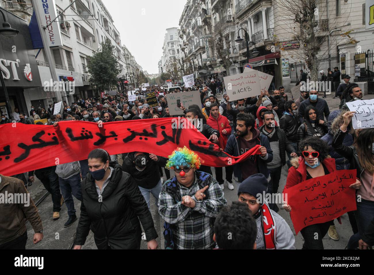 Les manifestants élèvent des pancartes alors qu'ils marchent dans les rues de la capitale Tunis pour protester contre la « violence policière » utilisée lors des dernières manifestations nocturnes qui ont éclaté dans le pays. Ils ont demandé la libération des jeunes manifestants arrêtés par la police. Des manifestants ont également protesté contre la déclaration du président du Conseil de Shura du parti islamiste tunisien Ennahdha, Abdelkarim Harouni, qui a déclaré : « les enfants d'Ennahdha seront sur le terrain pour soutenir les forces de sécurité ». Les manifestants scandaient des slogans, certains d'entre eux avaient marqué le soulèvement contre le RE autoritaire Banque D'Images