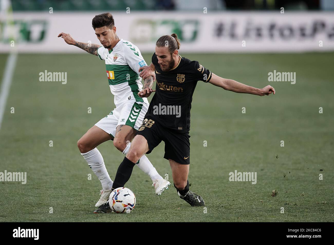 Emiliano Rigoni d'Elche et Oscar Mingueza de Barcelone concourent pour le ballon pendant le match de la Liga Santander entre Elche CF et FC Barcelone à l'Estadio Martinez Valero sur 24 janvier 2021 à Elche, Espagne. Les stades sportifs dans toute l'Espagne restent soumis à des restrictions strictes en raison de la pandémie du coronavirus, car les lois de distanciation sociale du gouvernement interdisent aux fans à l'intérieur des lieux, ce qui entraîne le jeu derrière des portes fermées. (Photo de Jose Breton/Pics action/NurPhoto) Banque D'Images