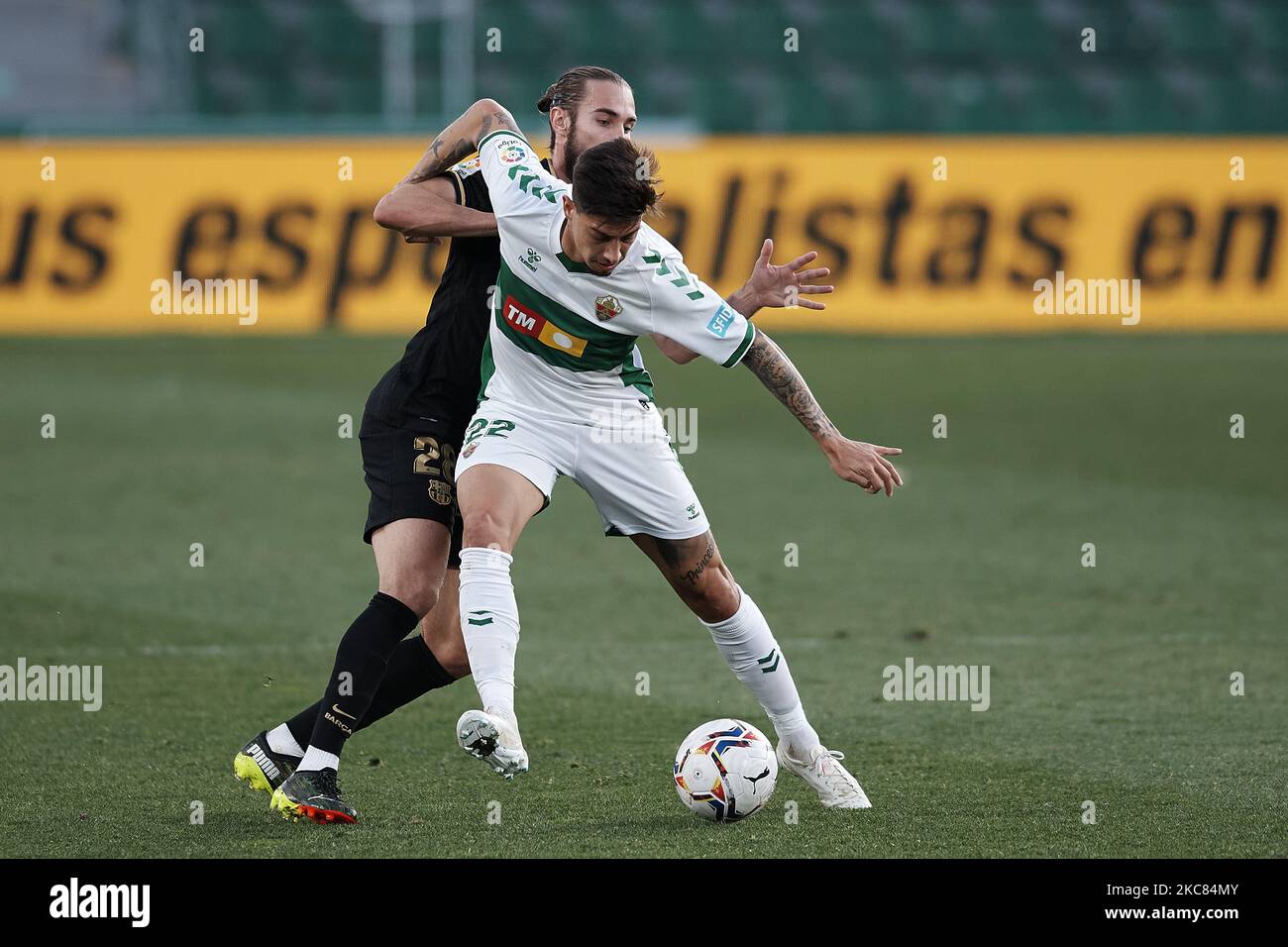 Emiliano Rigoni d'Elche et Oscar Mingueza de Barcelone concourent pour le ballon pendant le match de la Liga Santander entre Elche CF et FC Barcelone à l'Estadio Martinez Valero sur 24 janvier 2021 à Elche, Espagne. Les stades sportifs dans toute l'Espagne restent soumis à des restrictions strictes en raison de la pandémie du coronavirus, car les lois de distanciation sociale du gouvernement interdisent aux fans à l'intérieur des lieux, ce qui entraîne le jeu derrière des portes fermées. (Photo de Jose Breton/Pics action/NurPhoto) Banque D'Images
