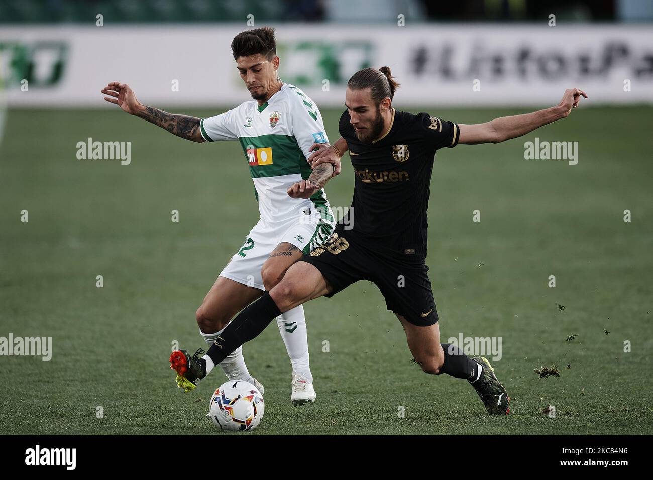 Emiliano Rigoni d'Elche et Oscar Mingueza de Barcelone concourent pour le ballon pendant le match de la Liga Santander entre Elche CF et FC Barcelone à l'Estadio Martinez Valero sur 24 janvier 2021 à Elche, Espagne. Les stades sportifs dans toute l'Espagne restent soumis à des restrictions strictes en raison de la pandémie du coronavirus, car les lois de distanciation sociale du gouvernement interdisent aux fans à l'intérieur des lieux, ce qui entraîne le jeu derrière des portes fermées. (Photo de Jose Breton/Pics action/NurPhoto) Banque D'Images