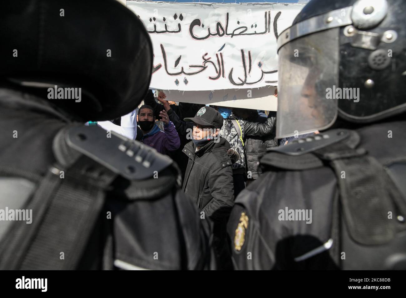 Un jeune manifestant vu devant des membres des forces de sécurité empêchant les manifestants de manifester devant le bâtiment de l'Assemblée des représentants du peuple (ARP) (Parlement tunisien) à Bardo. Des dizaines de jeunes du quartier difficile de Hay Ettadhamen, l'une des villes les plus peuplées de Tunis, sont descendus dans la rue dans une marche de protestation anti-gouvernementale qui a débuté de leur quartier et s'est dirigée vers la ville de Bardo à Tunis. Les manifestants ont particulièrement demandé la libération de jeunes arrêtés par la police lors des dernières manifestations nocturnes Banque D'Images